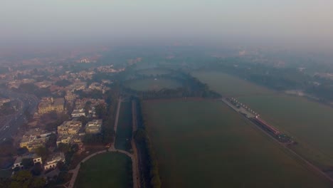 bombay, india, aerial flight over the horse riding ground and trraining areas, foggy weather of the city, traffic is going on the highway