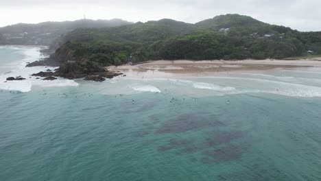 The-Pass-Beach-With-Surfers-In-Byron-Bay,-Australia---Aerial-Drone-Shot