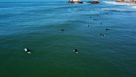 Luftaufnahme-Von-Surfern,-Die-Auf-Einem-Surfbrett-Liegen-Und-Darauf-Warten,-Dass-Die-Wellen-Surfen