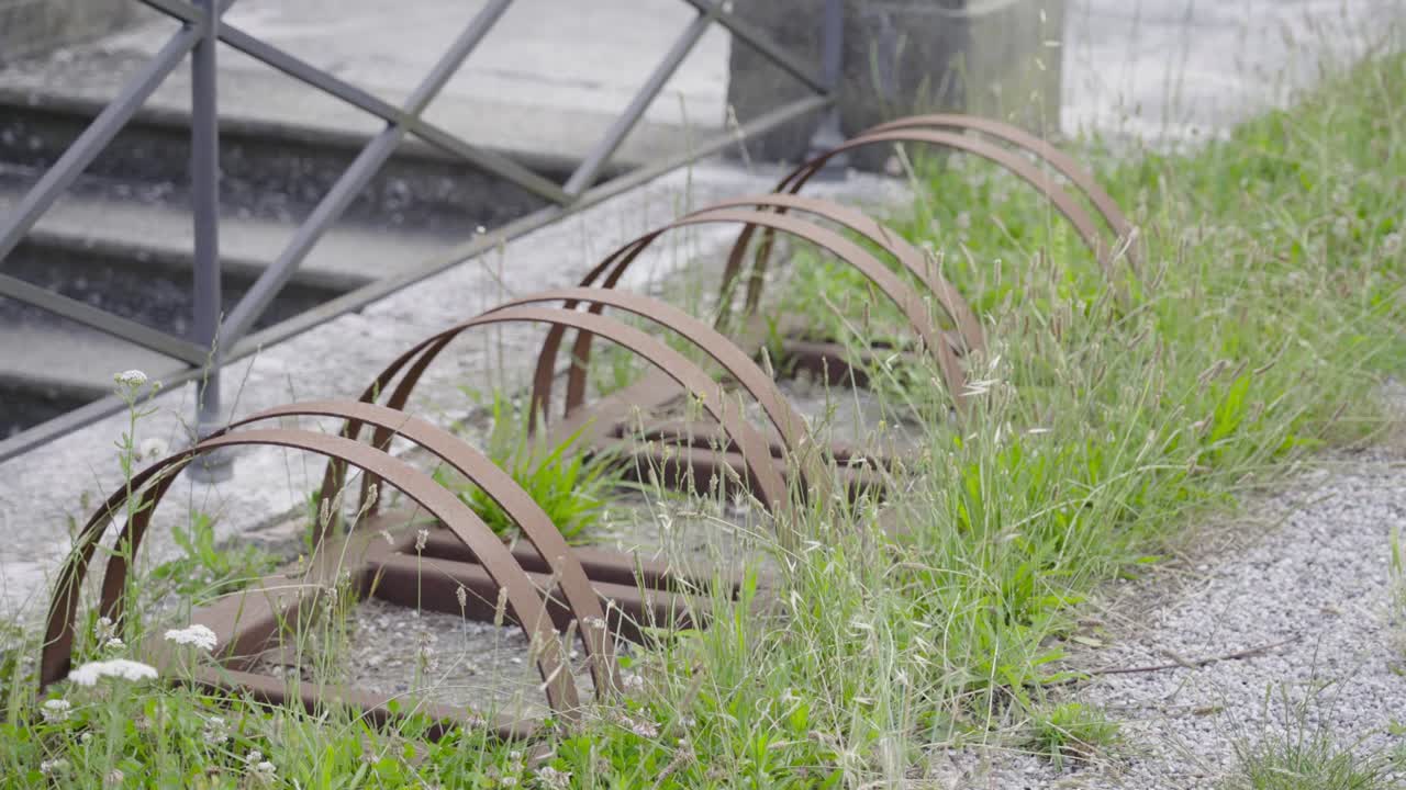 Ground rack for parking bicycles abandoned in the grass in the city