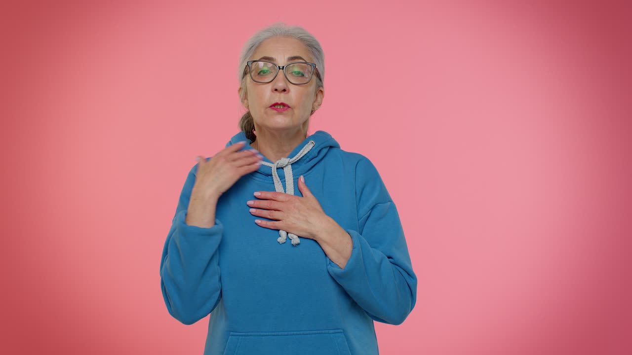 mujer mayor asustada cerrando la boca con la mano, gestos no, negándose a decir terrible secreto