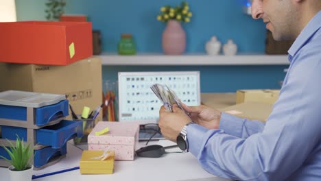 man selling in his online store is counting money.