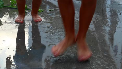 siblings children happy wet feet jumping up and down in water puddle, barefoot child´s play outdoor fun - games childhood siluete reflections infant toddler kids h2o boys forever young