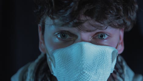 el joven se pone la máscara de precaución del virus de la corona con capucha 4k