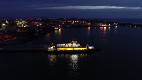 Aerial-Flying-Towards-Ship-Being-Unloaded-At-Night-At-Marina-Port-Pier