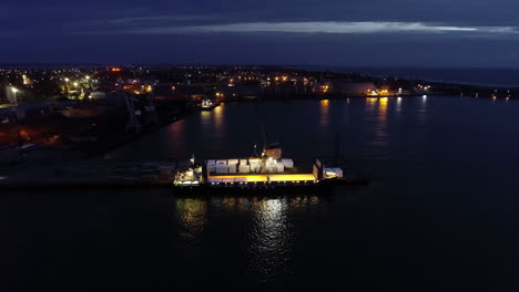 vuelo aéreo hacia el barco que se descarga por la noche en el muelle del puerto deportivo