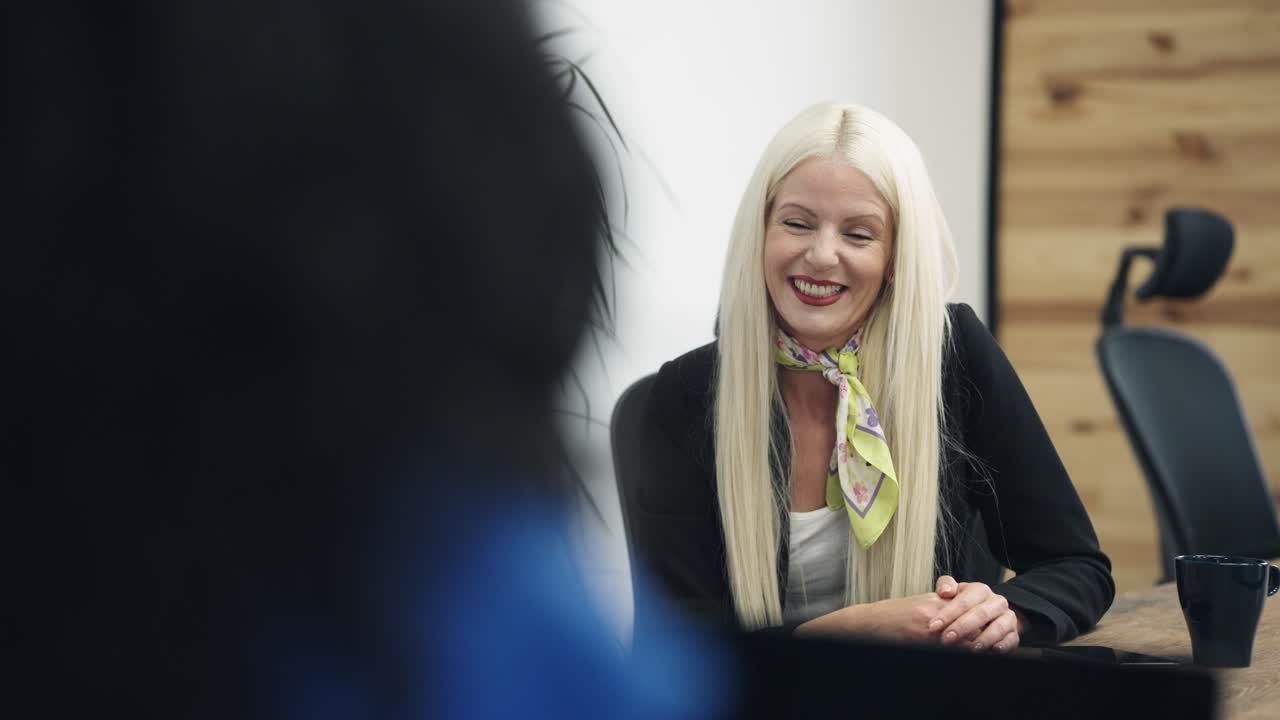 Blonde Businesswoman Smiling and Listening in an Office Meeting