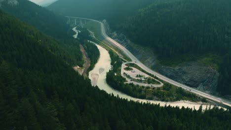 Columbia-Shuswap,-Highway-and-Forest-Trees,-Hazy-Wildfire-Smoke,-Wide-Establishing-Aerial,-British-Columbia,Canada