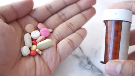 un puñado de pastillas y un frasco de medicina