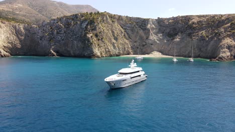 large yacht docked in remote beach bay, coast of asos in greece, scenic panorama