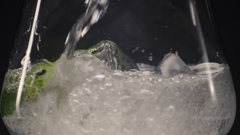 Cold-liquid-pouring-mint-wineglass-closeup.-Homemade-mineral-cocktail-concept