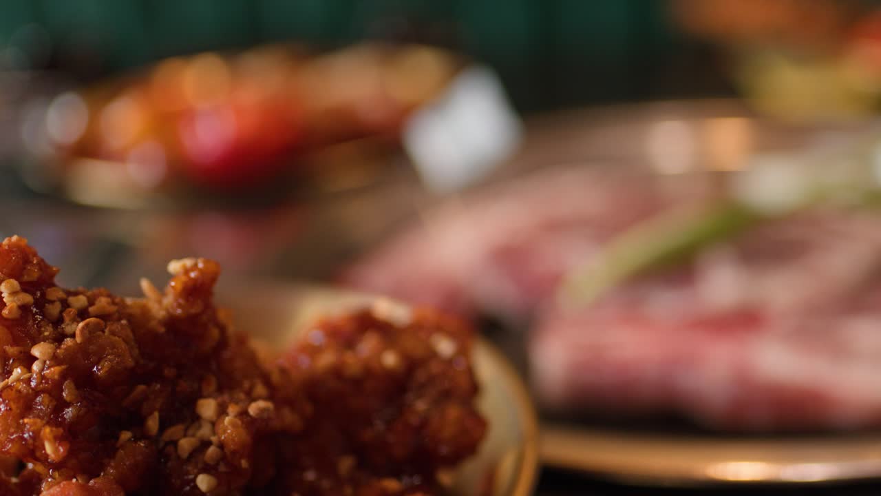 Crispy Korean fried chicken in focus, warm lighting, shallow depth of field, restaurant setting