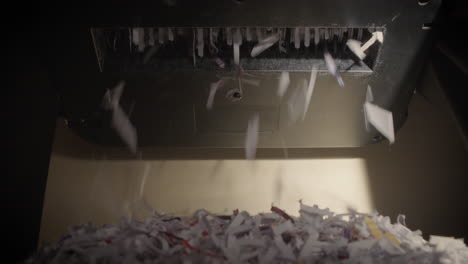 Shredder-Cutting-Paper-From-Below,-Half-Full-Basket,-Hard-Light