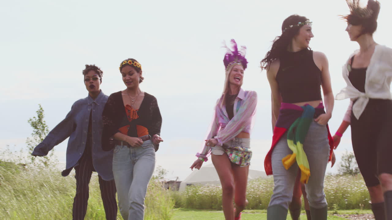 음악 페스티벌 장소 를 걸어다니는 흥분 된 젊은 여성 친구 들 의 그룹