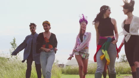 grupo de jóvenes amigas emocionadas caminando por el sitio del festival de música