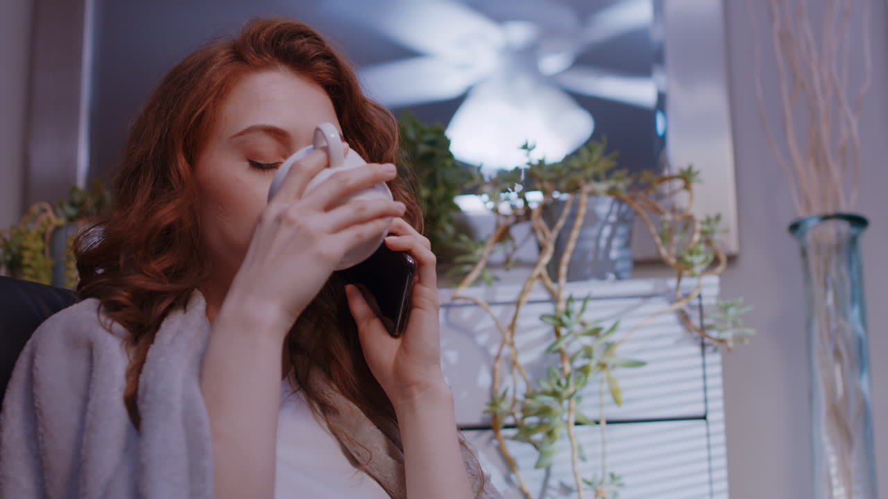 젊은 백인 여성이 휴대전화로 이야기하고 중립적인 대화를 나누고 있습니다.