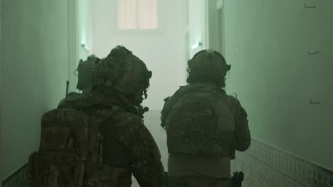 back view of group of men playing airsoft indoor