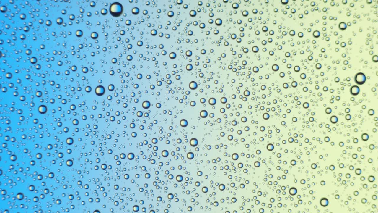 gotas de agua en la superficie del vidrio en azul y amarillo