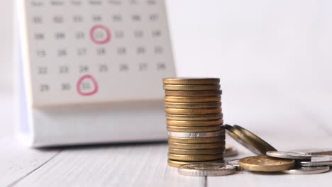 stack of coins near a calendar: financial planning and savings