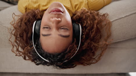 mujer escuchando música en un sofá
