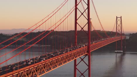 aerial right to left orbit around international orange suspension bridge and christus statue in background