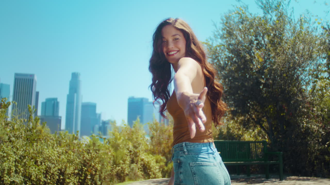 공원에서 남자친구를 이끌고 있는 젊은 소녀. 아시아 소녀가 친구를 불러서 그녀를 따라간다.