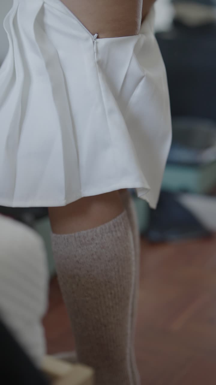 Woman Putting On White Mini Skirt