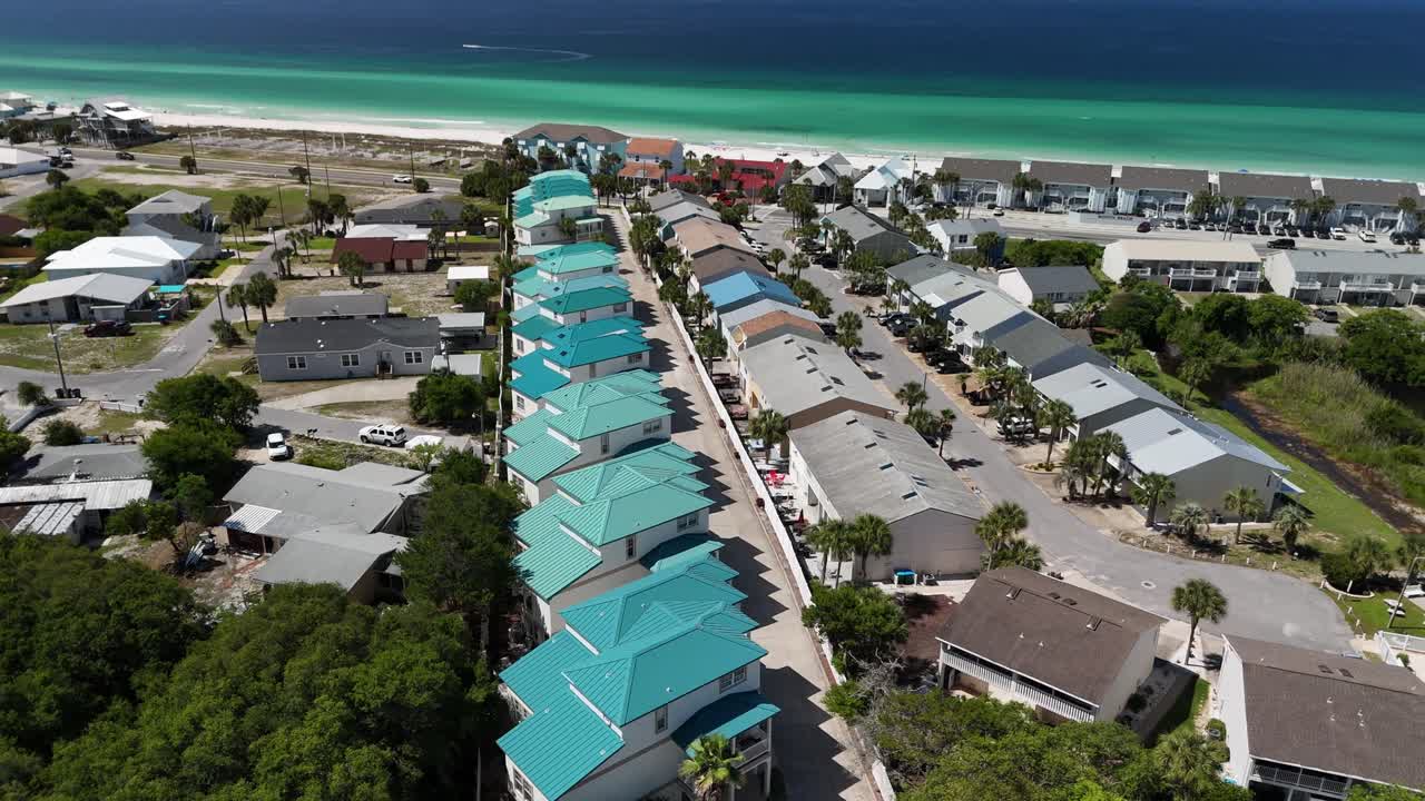 Sideways drone movement on a turquoise oceanfront resort with uniform beachside community, Panama City Beach, Florida, USA