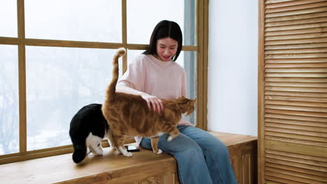 Woman-with-cats-by-the-window