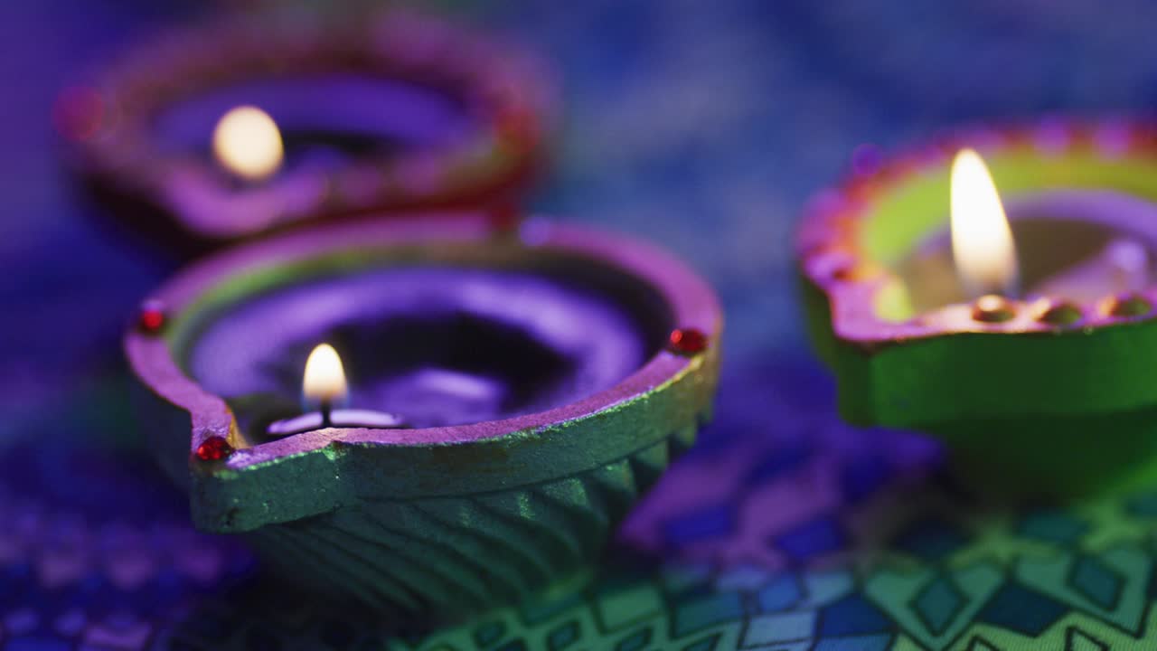 velas encendidas en ollas de arcilla decorativas en la mesa con patrones, enfoque en primer plano, fondo bokeh
