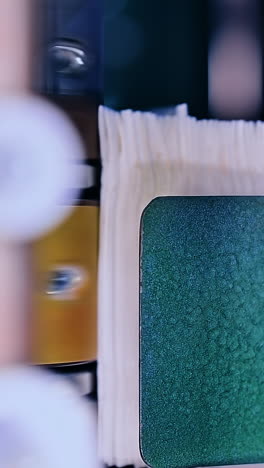 big metal roller twisting and pushing the non-woven cloth into conveyor. production line of diapers at the factory close up. vertical video