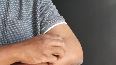hombre rascándose el brazo
