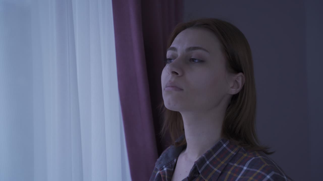 La donna che guarda fuori dalla finestra è pensierosa