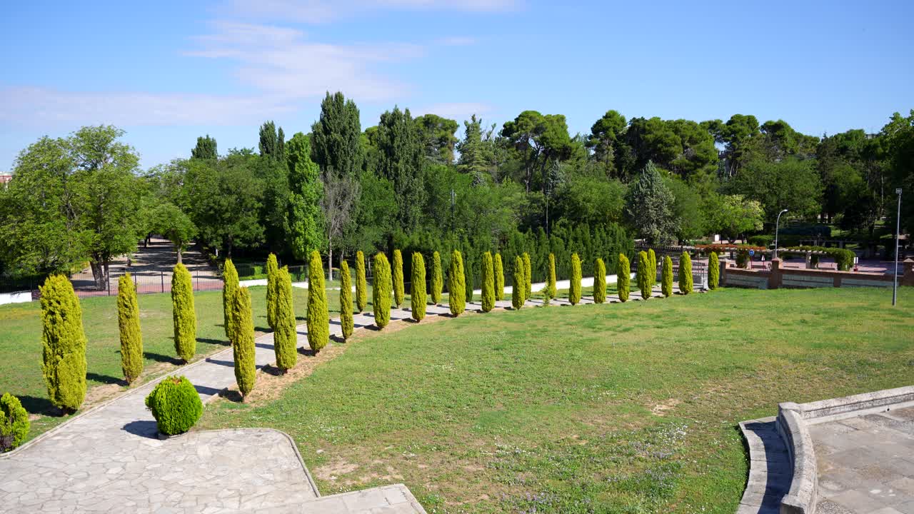 Panoreringsbild av en stig kantad av cypresser vid hertiginnan av Sevillanos panteon, Guadalajara, Spanien.