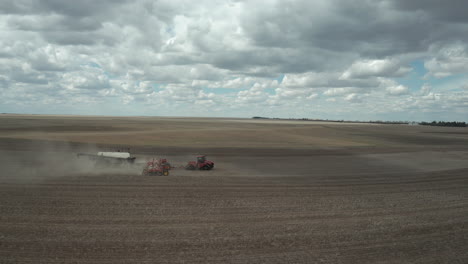 granjero con tractor sembrando cultivos en el vasto campo en saskatchewan, canadá