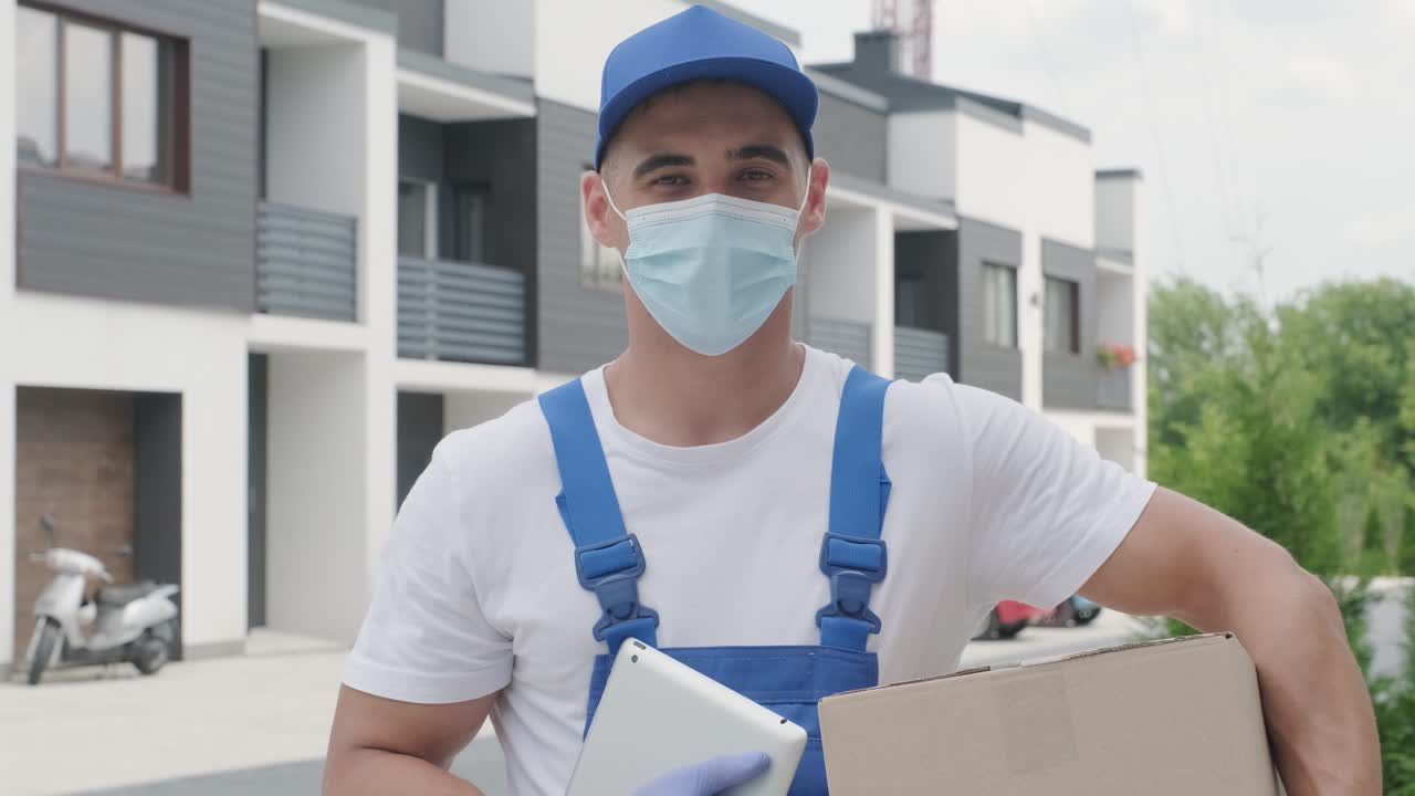 retrato de un joven mensajero de correo con máscara y guantes, que está entregando un paquete directamente a la casa de un cliente con seguridad. entrega a casa en cuarentena