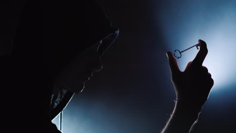 the silhouette of a man in a hood with a key in his hand the concept 4k video