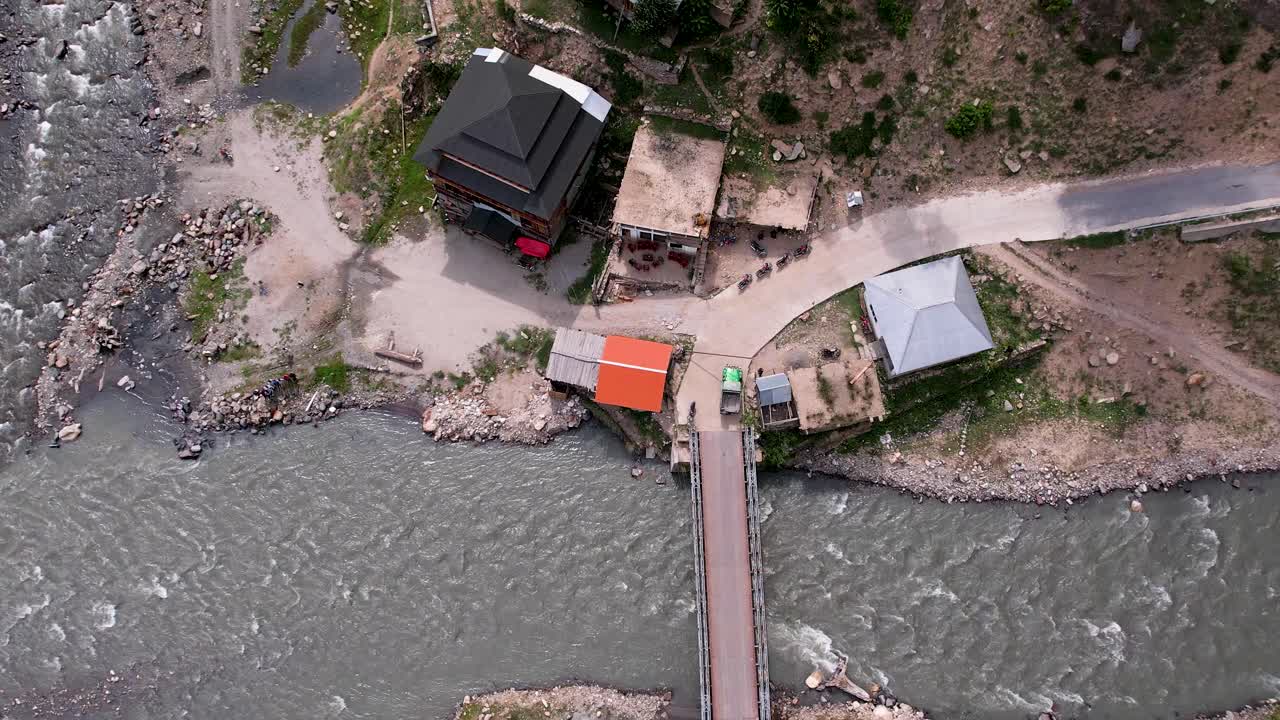 a bridge over Surgen Nala with houses, riverside structures, and unique valley architecture
