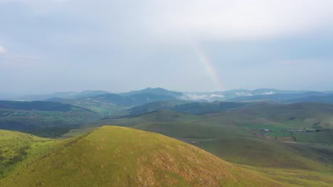 rainbow over the hills of pester, serbia on a cloudy day -aerial