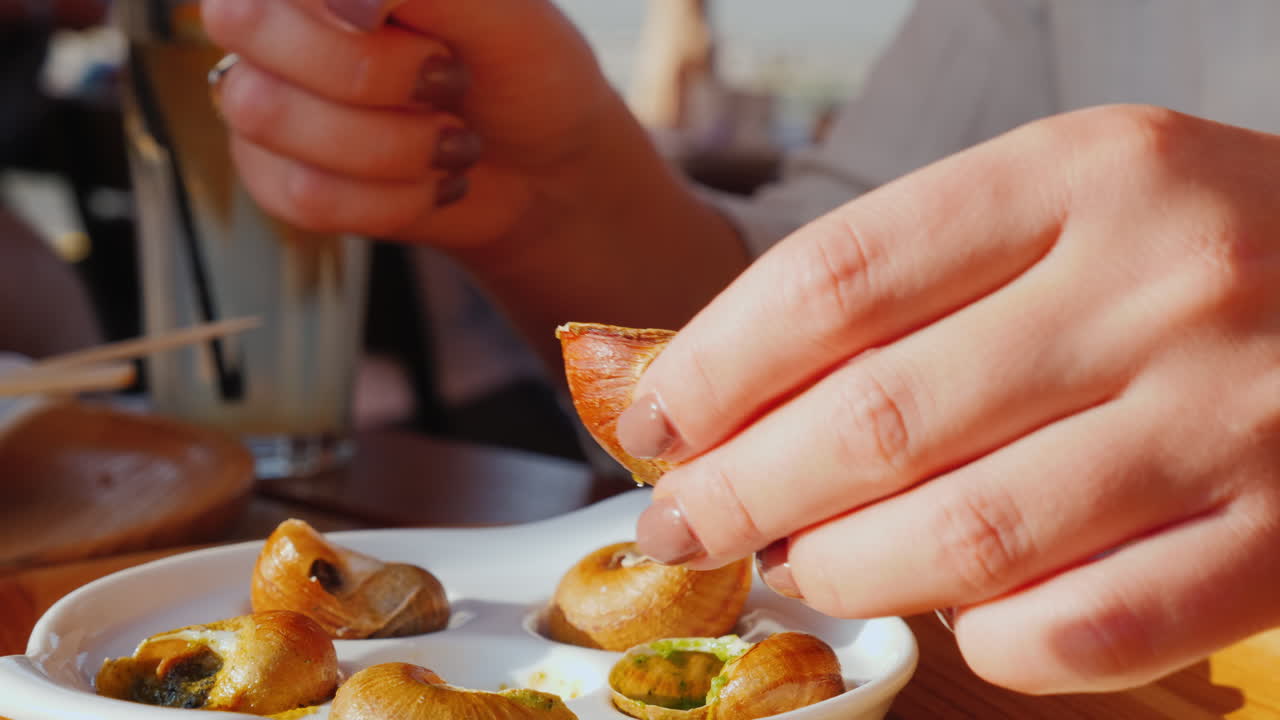 una mujer come caracol con salsa