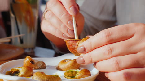 una mujer come caracol con salsa