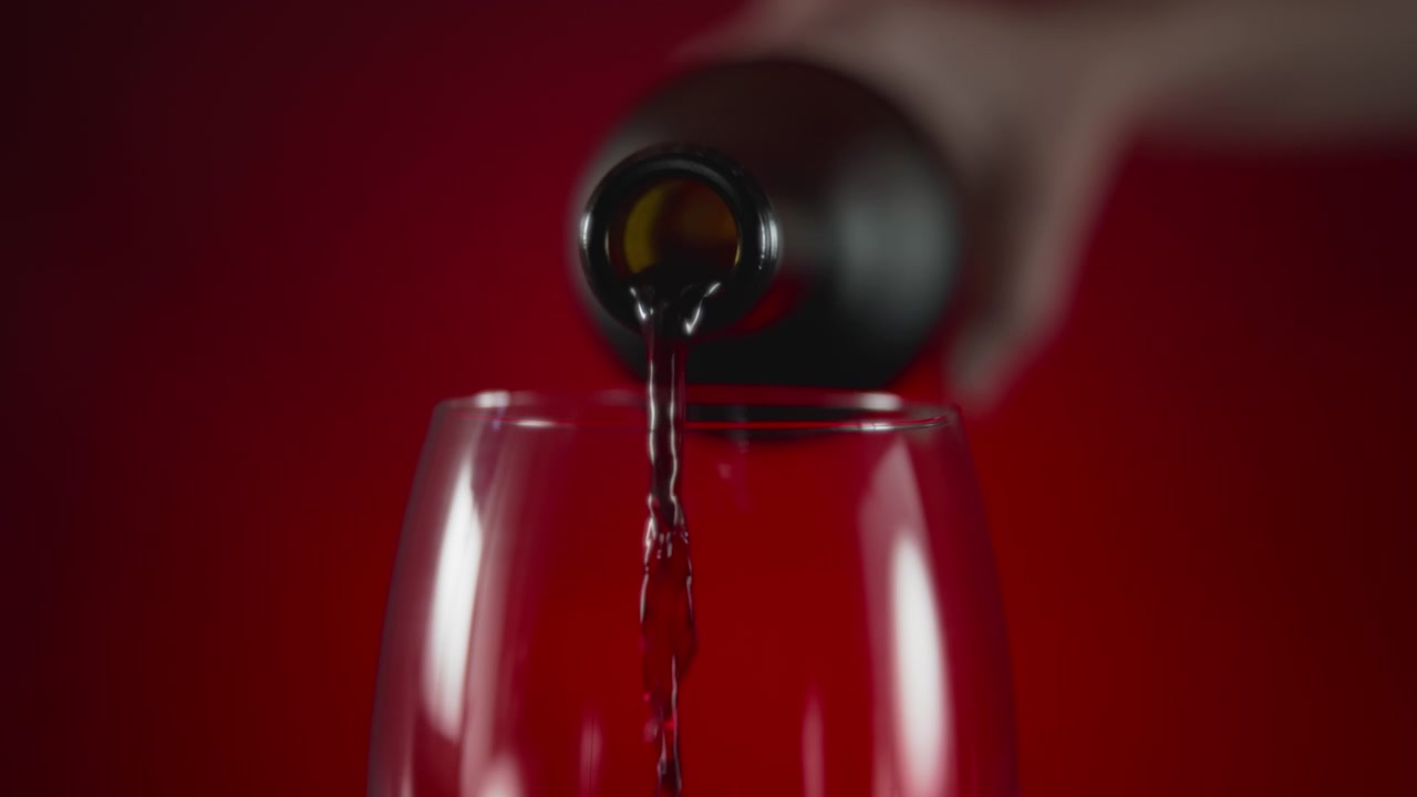 Vino rosso versato dalla bottiglia.