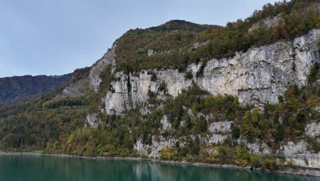 Aerial-view-of-Lake-Walen-with-rocky-mountains-in-Weesen,-Switzerland---Forward-flight