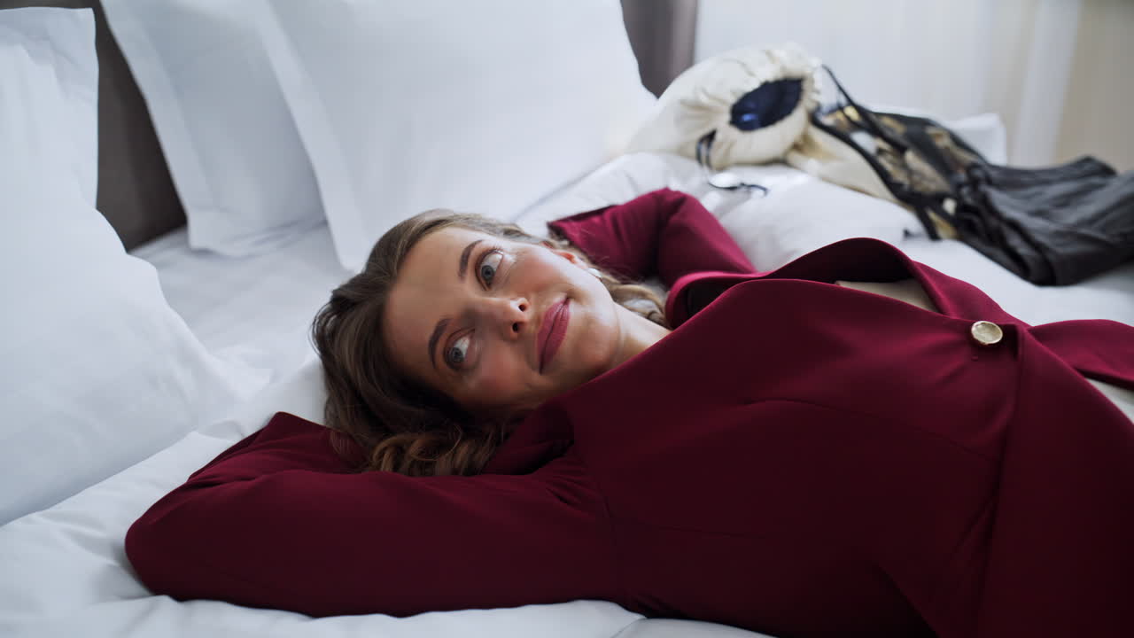 Businesswoman falling hotel bed enjoying atmosphere closeup. Smiling woman lying