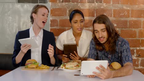 colleagues discussing over digital tablet at desk 4k