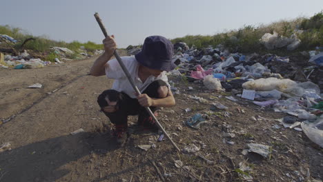 child searching for recyclable materials in a landfill