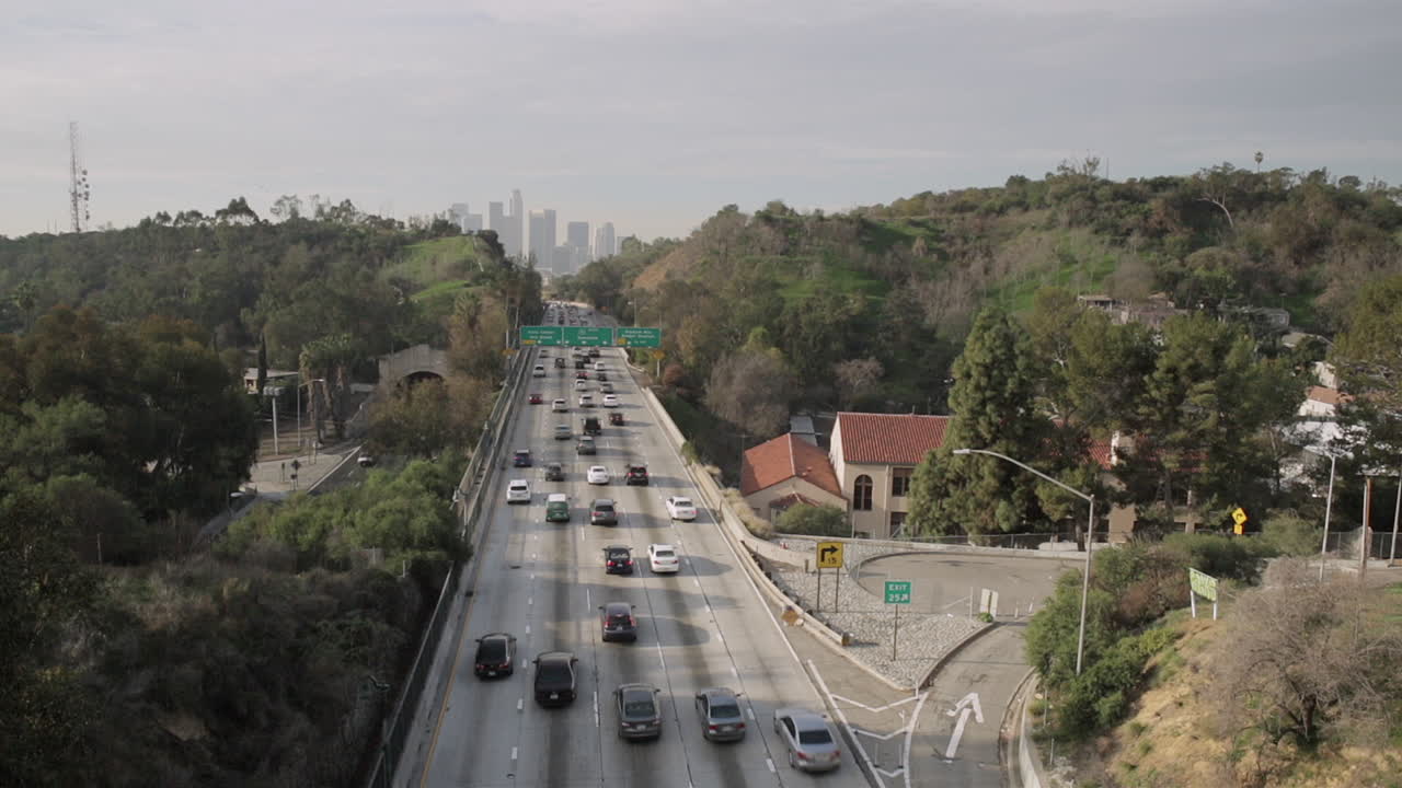 A busy highway and downtown Los Angeles from a bridge on a sunny day.