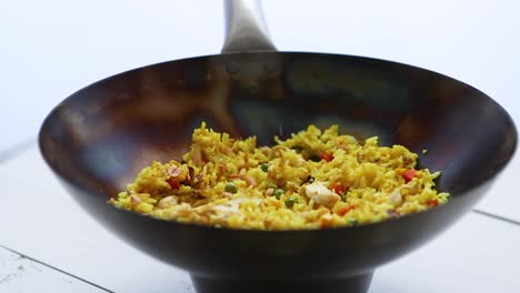 Delicious-Thai-dish-in-hot-Wok--Fried-chicken-with-rice-and-vegetables-with-falling-peanuts