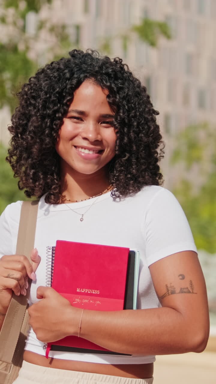 Ragazza afroamericana riccia, studentessa con borsa di scuola e libri