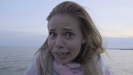 una chica loca y divertida juega con una cámara de helicóptero en la playa.